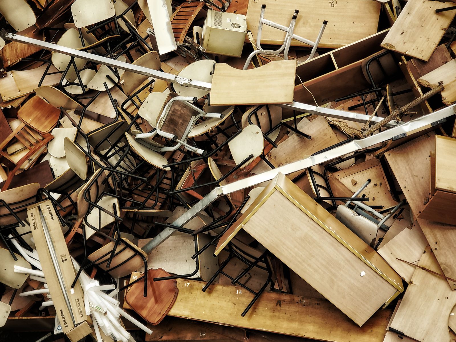 A pile of old chairs, desks and furniture